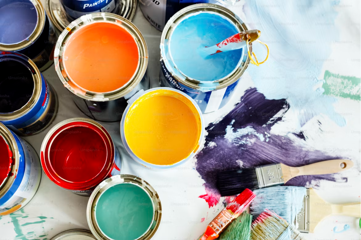 Colourful paint tins and brushes for interior decorating, home improvement, DIY painting, and renovation projects.