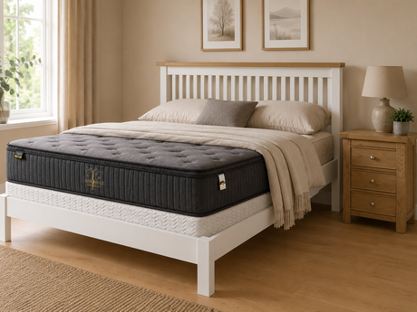 White slatted bed frame with oak top trim, grey tufted mattress, three-drawer oak bedside locker, neutral pillows, soft throw, and warm cosy Irish bedroom décor.