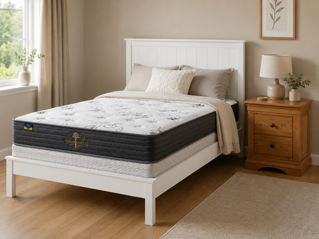 White wooden bed frame with a paneled headboard, floral tufted mattress, oak two-drawer bedside locker, neutral pillows, soft throw, and warm cozy Irish bedroom décor.